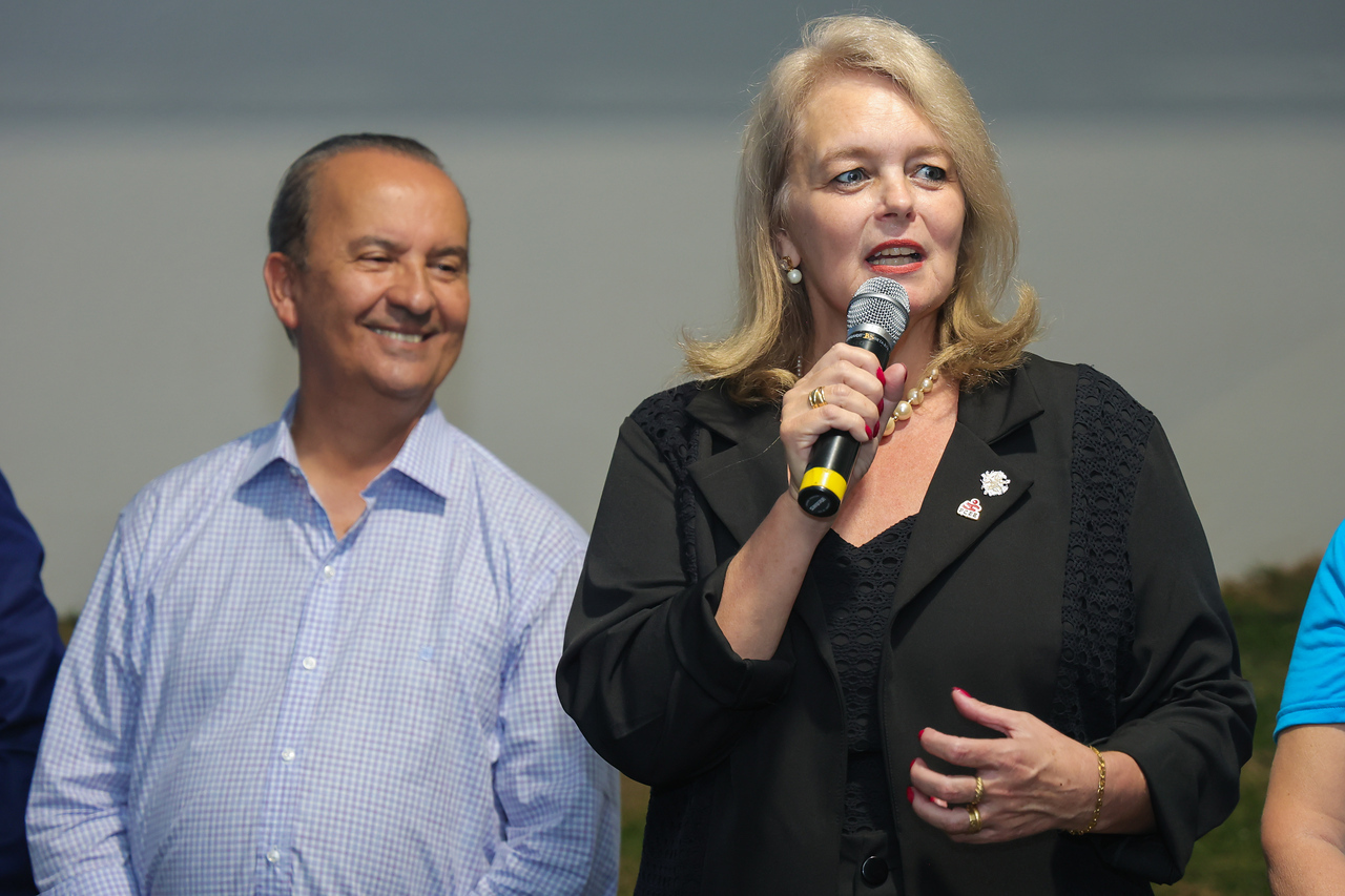 Governador e presidente da FCEE na inauguração da Ama Oeste imagem com duas pessoas, uma mulher loira falando ao microfone e um homem sorrindo