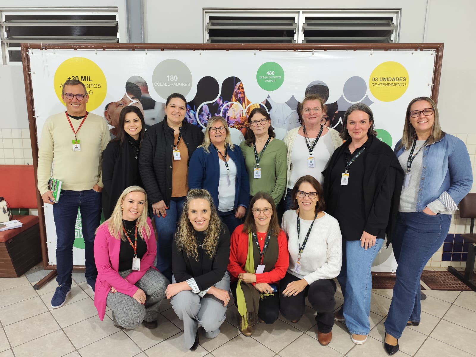 Visita na APAE de Jaraguá do Sul Vinte pessoas posam para foto em ambiente interno