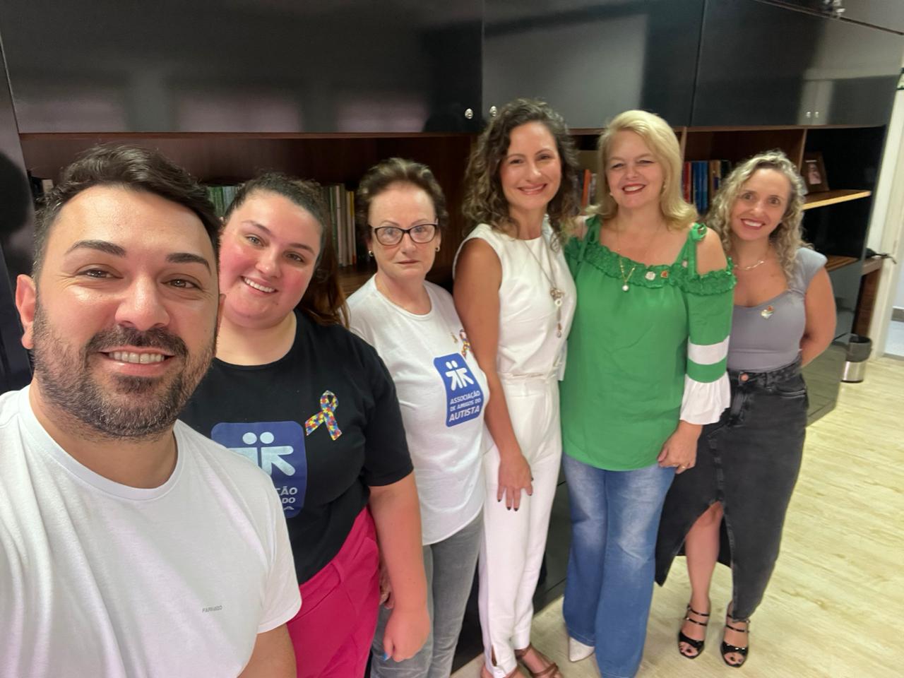 Encontro na AMA de Joaçaba Ambiente interno, 6 pessoas posam para foto sorrindo.