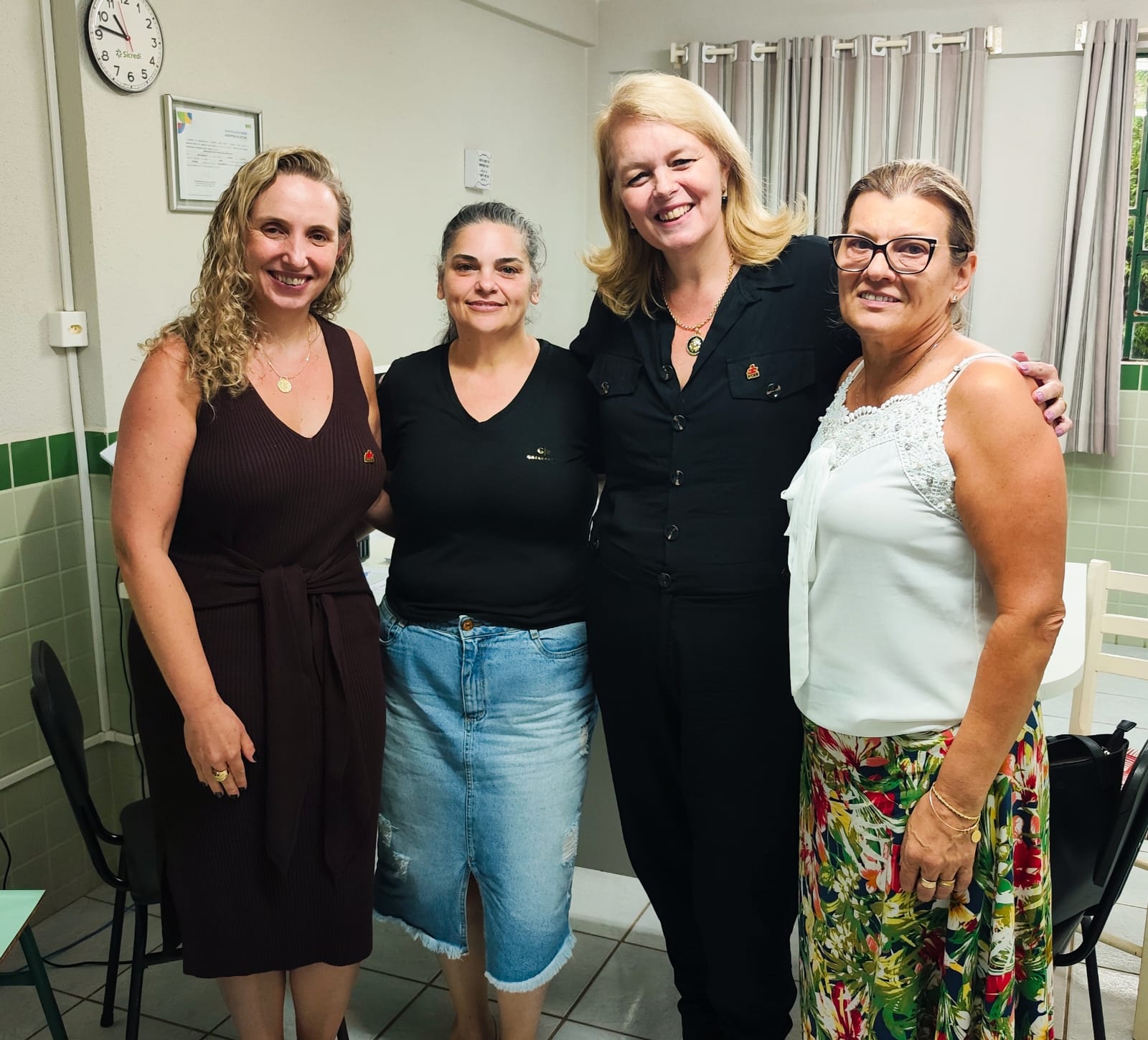 Reunião na Apae de Seara Ambiente interno, 4 mulheres em pé posam para foto sorrindo