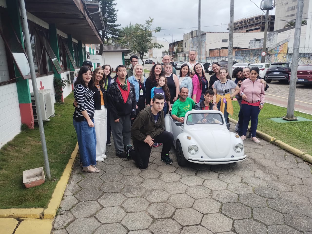 Campanha Paz no Trânsito na FCEE 15 pessoas ao lado de fusca em miniatura, ambiente externo, rua
