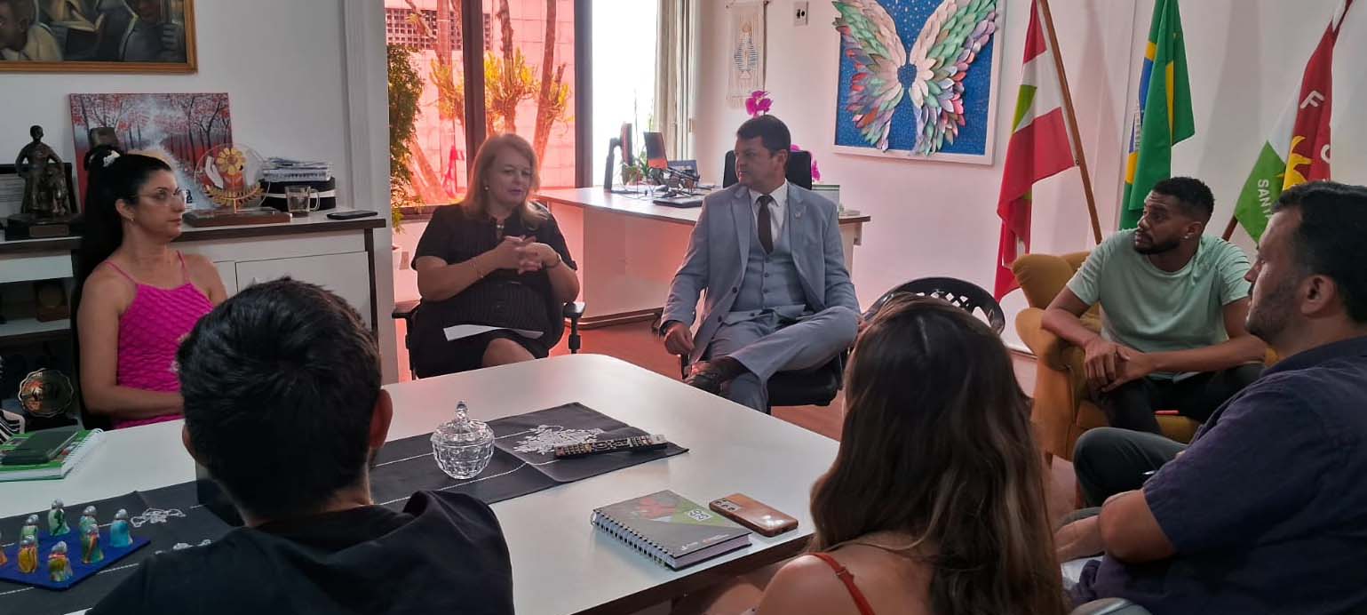 Controlador-Geral do Estado em reunião na FCEE Seis pessoas sentadas em ambiente interno, mesa de reuniões