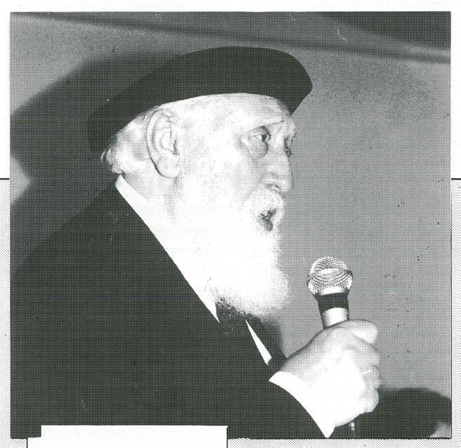 Professor Feuerstein esteve na FCEE em 1995 Foto preto e branco antiga de homem com barba branca comprida e chapéu falando ao microfone