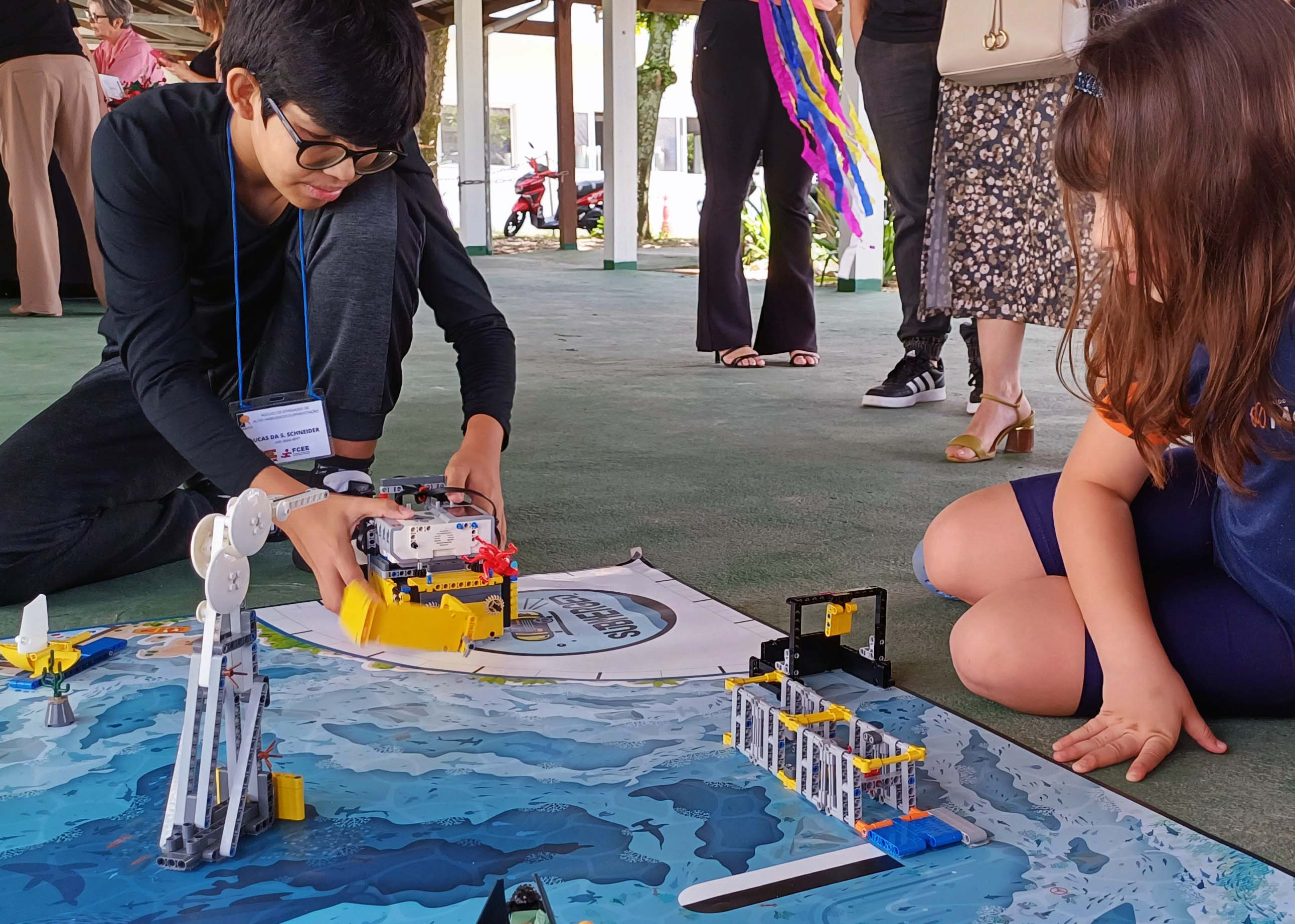 Atividades na FCEE com alunos do Núcleo de Altas Habilidades duas crianças sentadas no chão mexem em estruturas de Lego